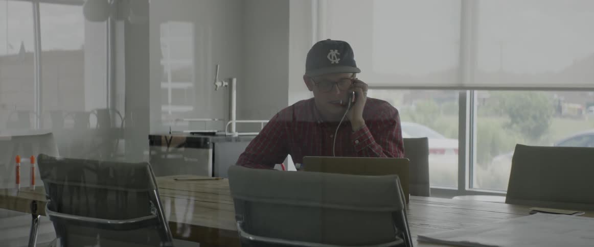A young man works at a table with a laptop