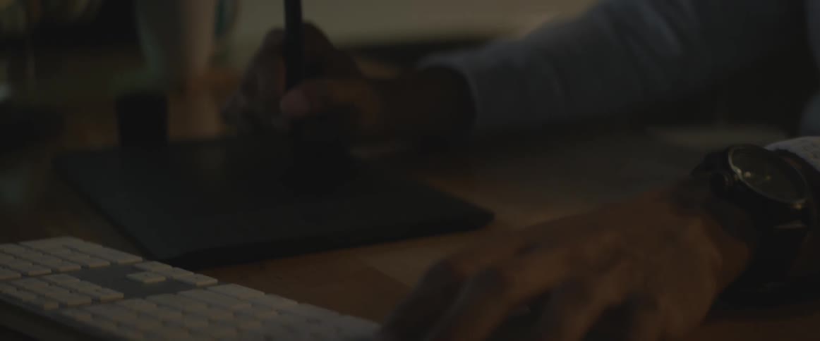 A person is writing near a computer