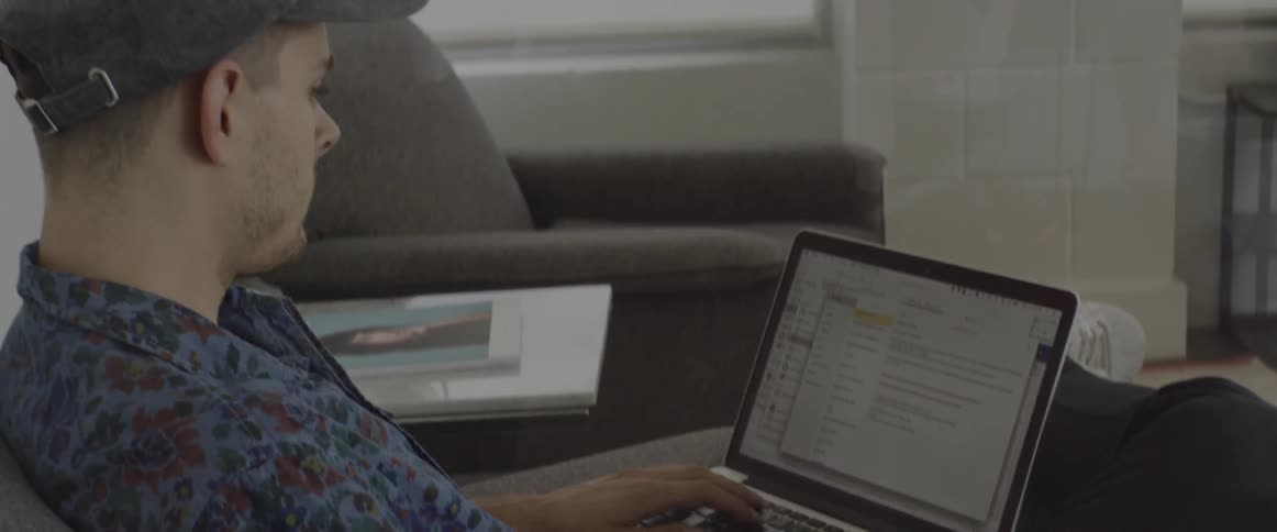 A man is sitting using a laptop