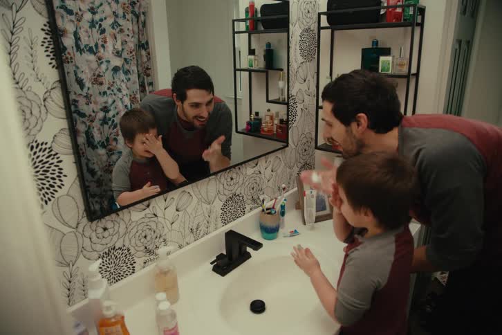 Father washing hands with his son in the bathroom playing and putting soap on their noses