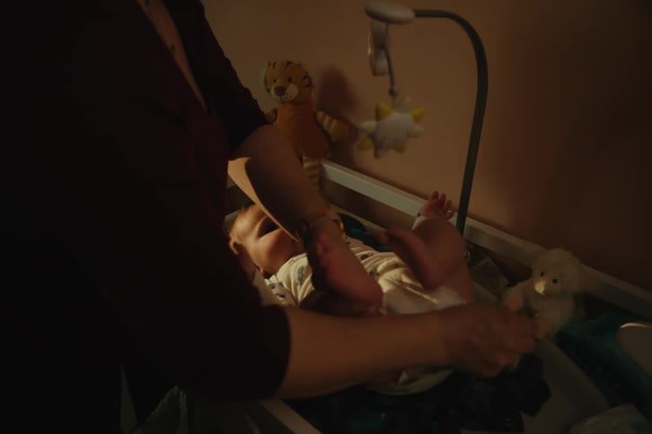 Mother changing babys diaper