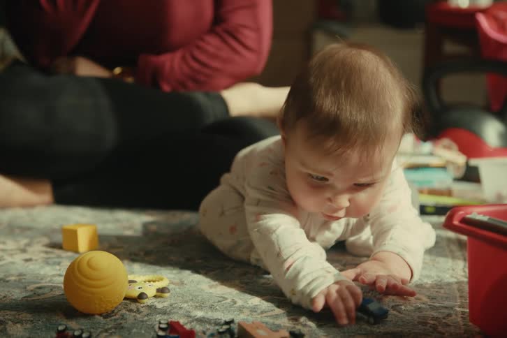 Baby on the carpet playing with an adult