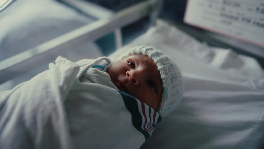 The newborn is wrapped in a blanket