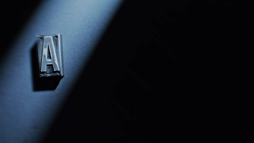 The letter a is revealed by light as it is displayed on a wall