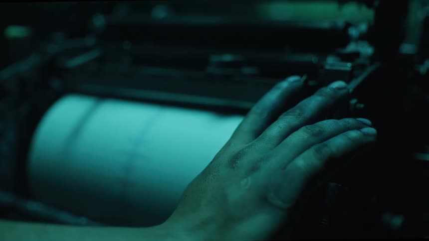 Greasy hand touches a large industrial roller