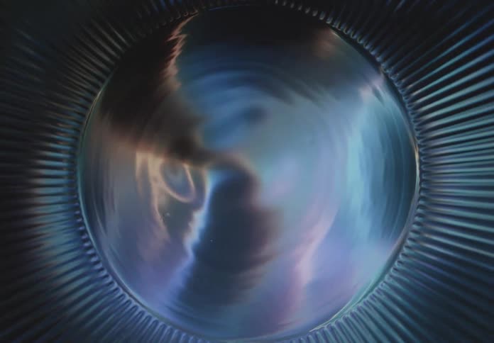 An abstract dark sphere centered within a blue ribbed circular structure the spheres surface reflects dynamic fluid patterns of light and color resembling a nebula or an internal energetic discharge the word filmsupply is overlaid on the sphere