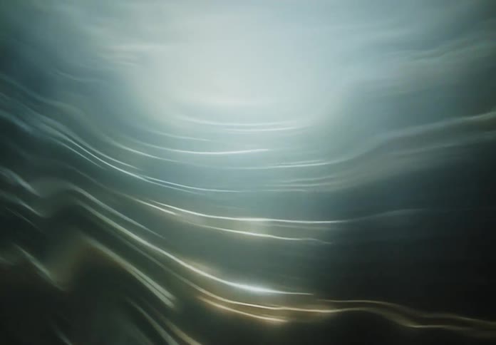 Rays of blue light pass through the wavy surface