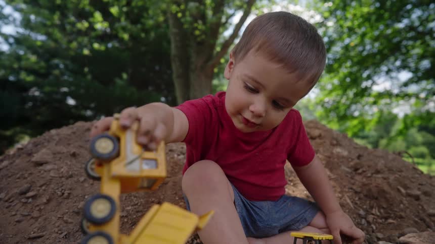 Boy playing with toys in an outdoor land