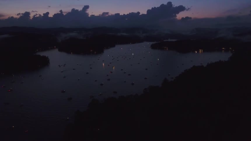 Boats cover a small lake at sunset