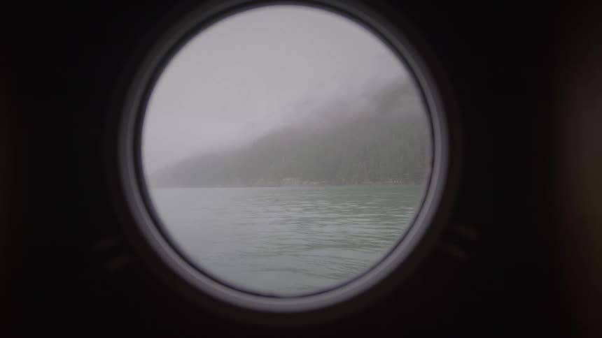 Through the window of the boat thick fog is ono the shore
