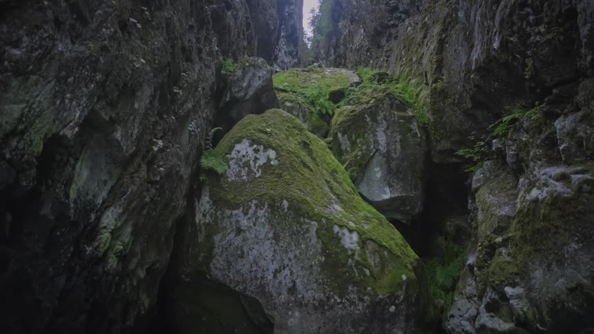 Boulders are in the crevice of the mountain