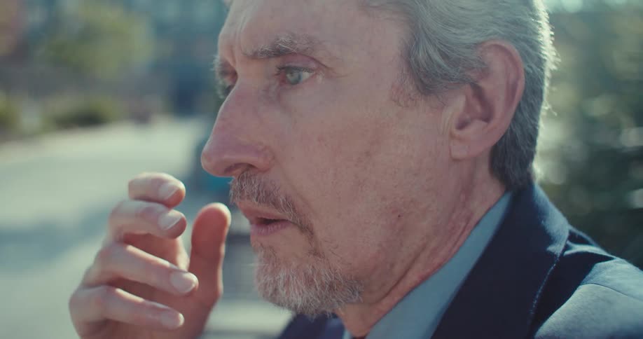 Man in suit with puzzled expression looking at smartphone