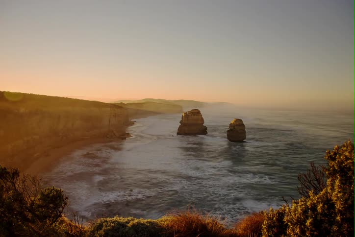 Waves crash against the shore at dawn