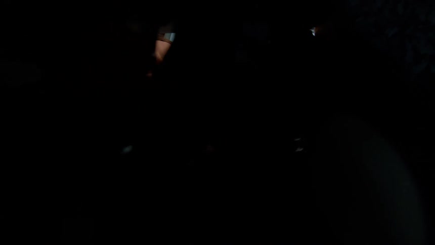 Woman with a child in her arms picking up christmas lights from a box