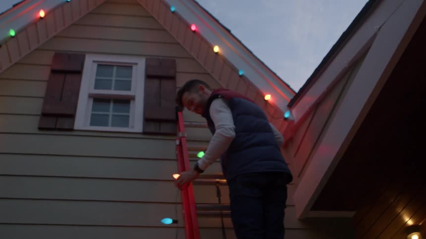 A family are hanging christmas ornaments on the home