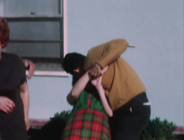 A man holds a woman and kisses her