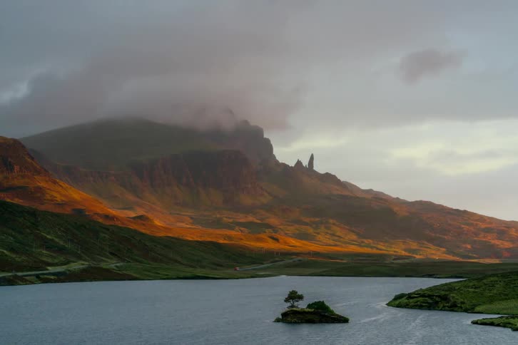 Clouds move over the mountain past the water