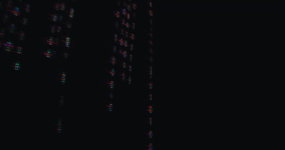 On a digital display columns of glowing numbers made of colored pixels fall down a black screen in a matrixlike effect