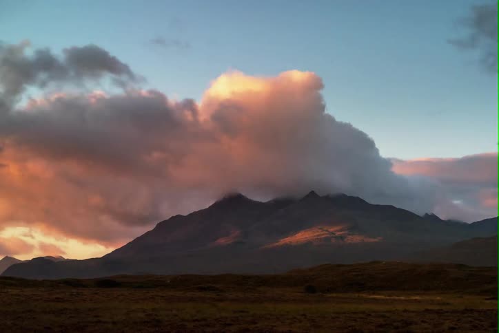 Clouds flowing over the top of mountain