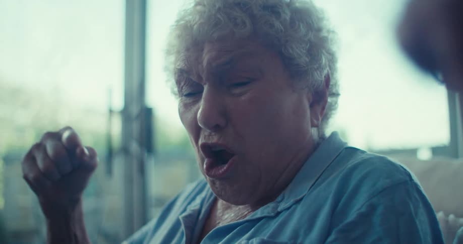 Two elderly people share a joyful laugh together in a bright indoor setting