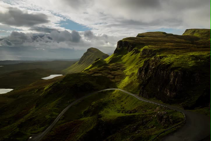Clouds pass over green mountains