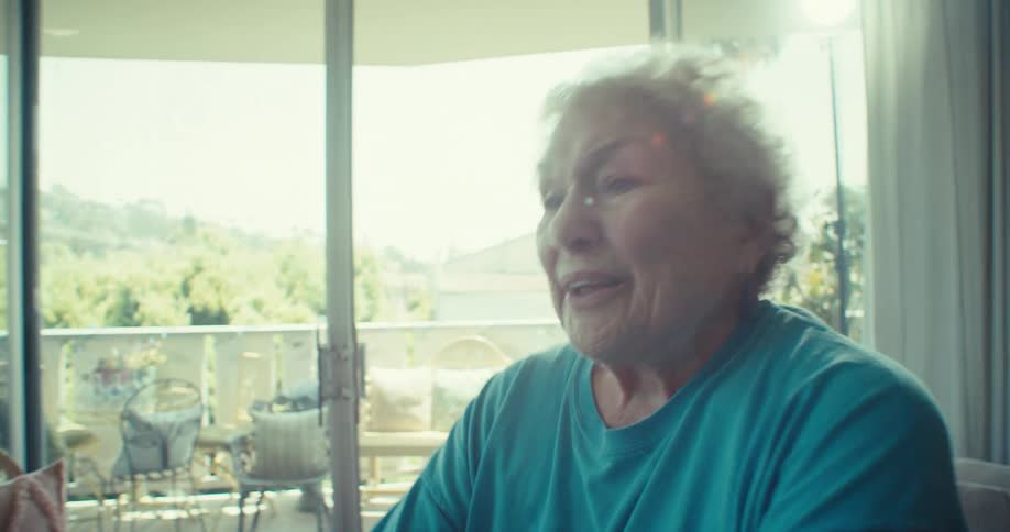 The woman is breathing heavily while using the exercise bike