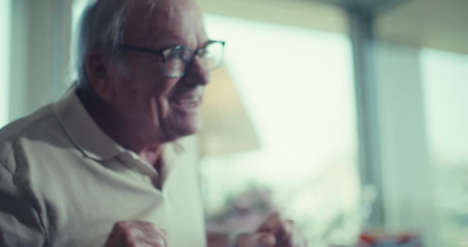 An elderly woman smilesat a man while moving in place quickly in a sunlit room