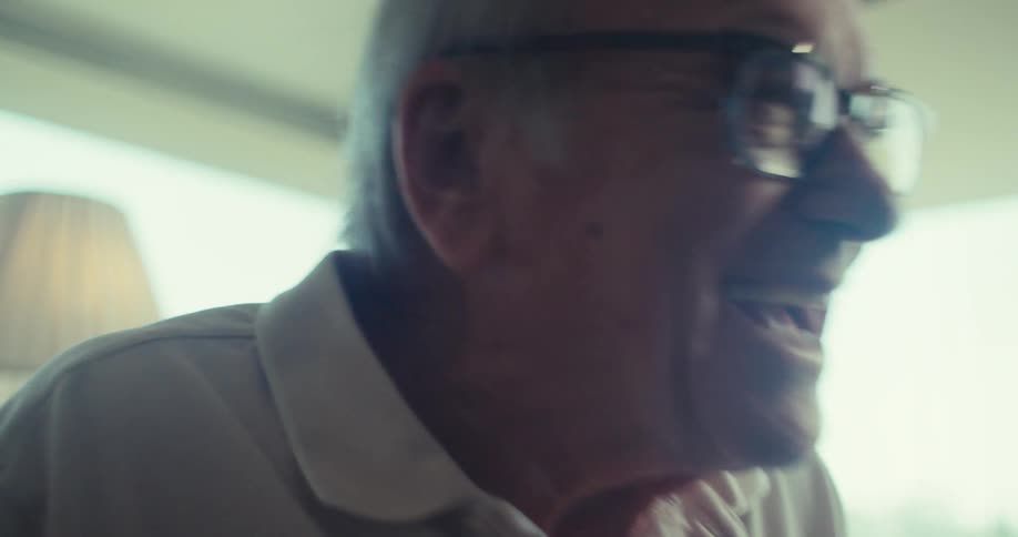 An elderly man smiles while talking to an elderly female companion