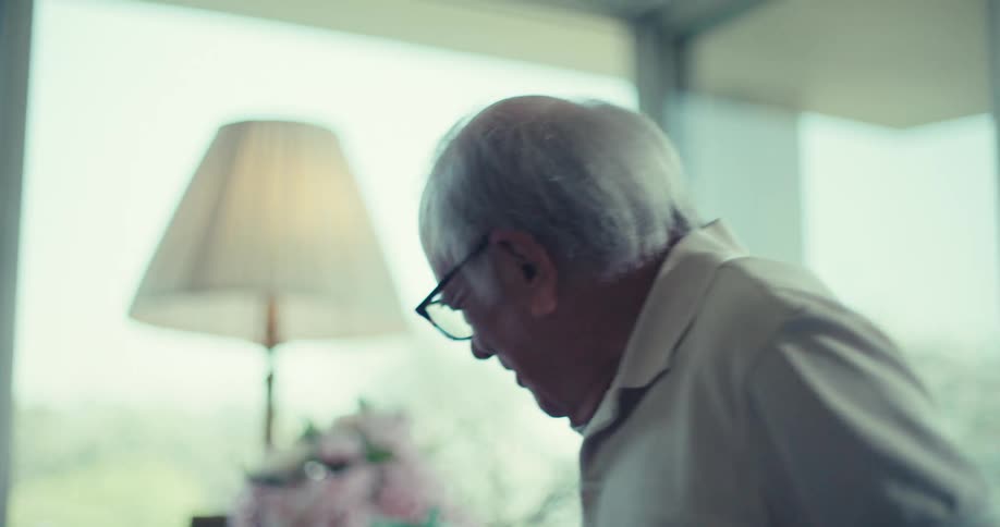 An elderly woman with short curly white hair smiles warmly and laughs as she claps her hands then highfives an unseen individual the camera then reveals her and an elderly man sharing a moment before she is handed a water bottle