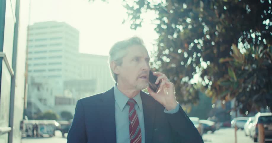 Man in suit walking and talking on a phone call