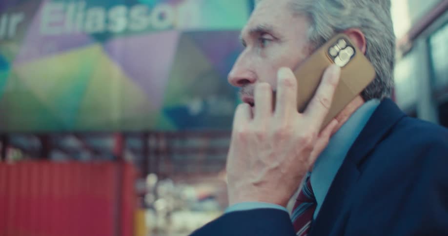 A walking man answers his phone and gets angry