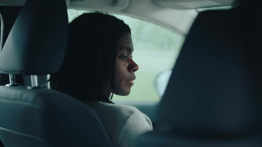 Two people sitting in the front seat of a vehicle talking