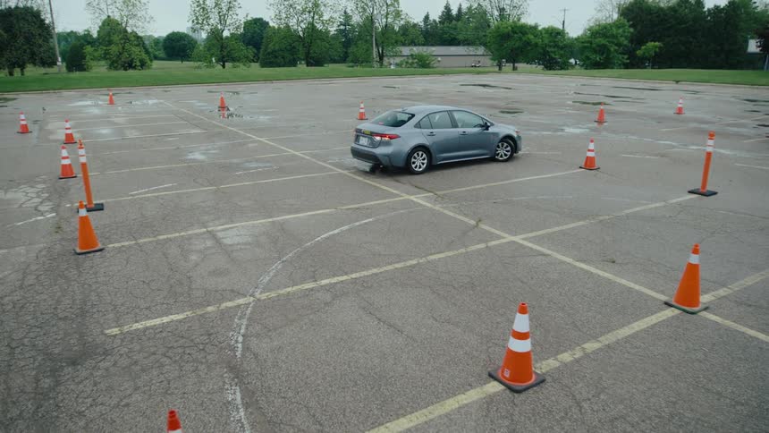 Sedan car moving along a track with cones