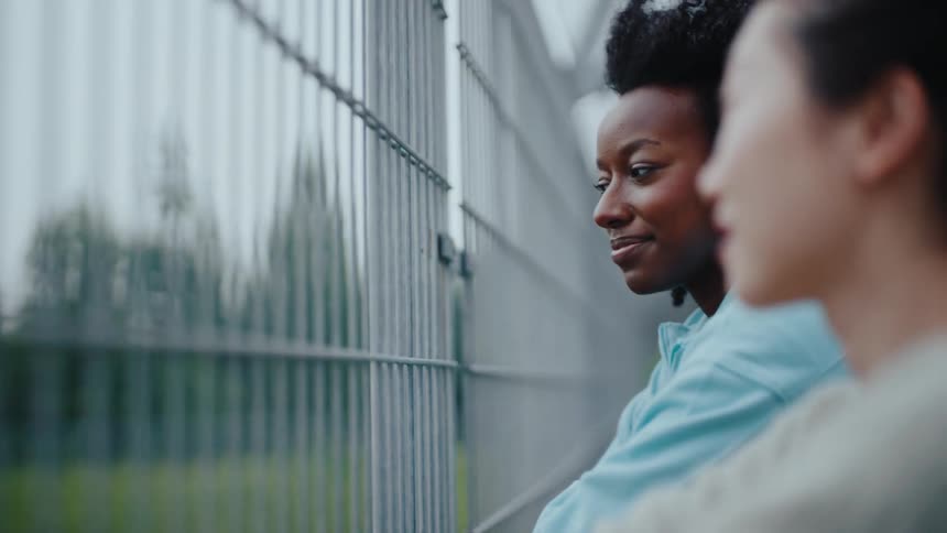 Two women on an overpass talking to each other
