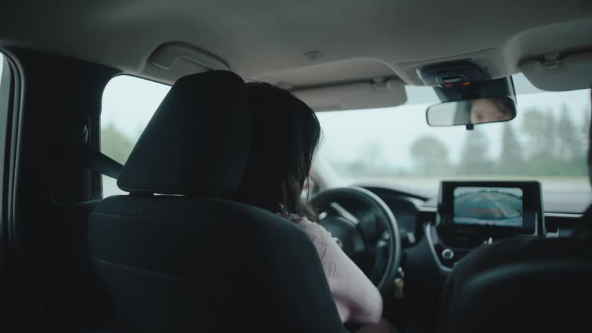 Woman in a driving school class reversing her vehicle accompanied by an instructor