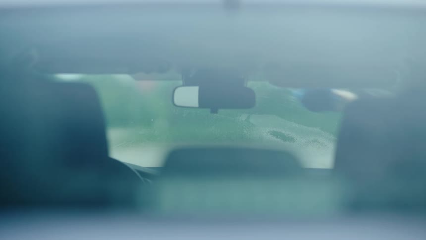 Person washing the windshield of a car