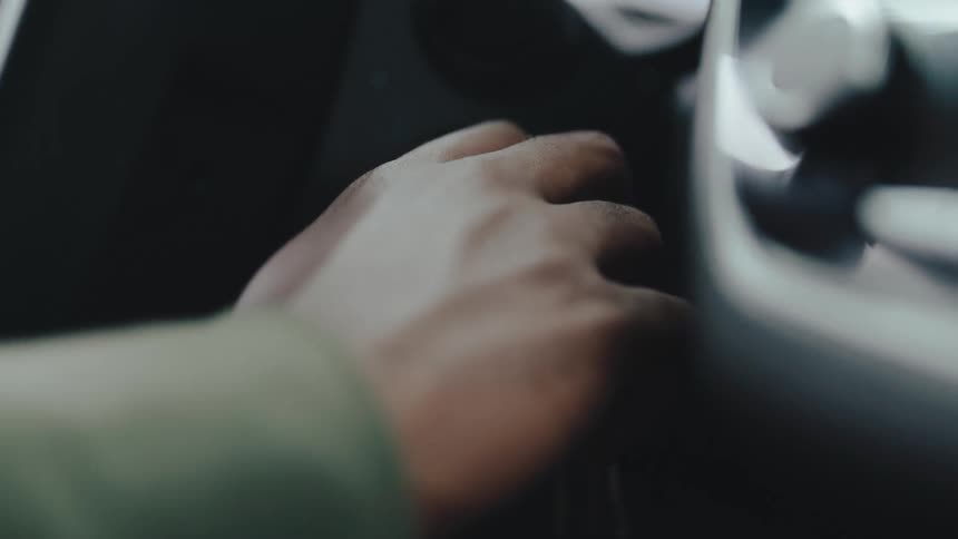 Close up of a driver starting a car in the ignition area