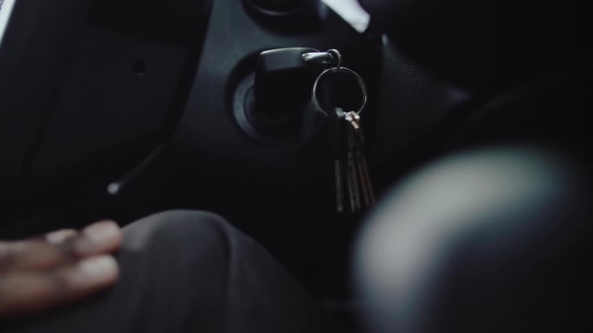 Hand tapping a leg and a key in the ignition of a vehicle