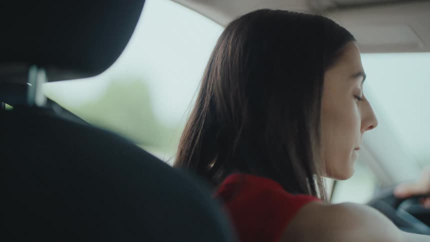 Woman steers a car during the daytime