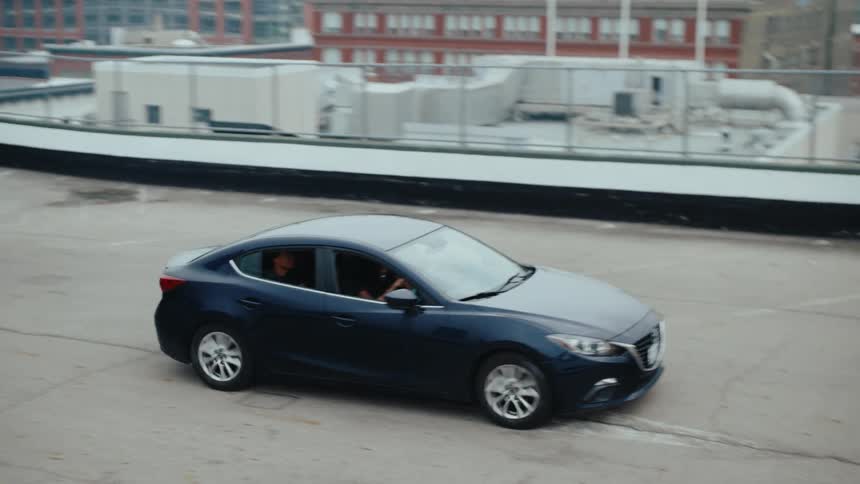 Sedan car with a group of people inside being parked in a building area