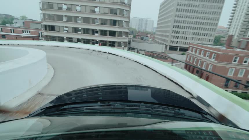 A car drives into a parking lot at midday