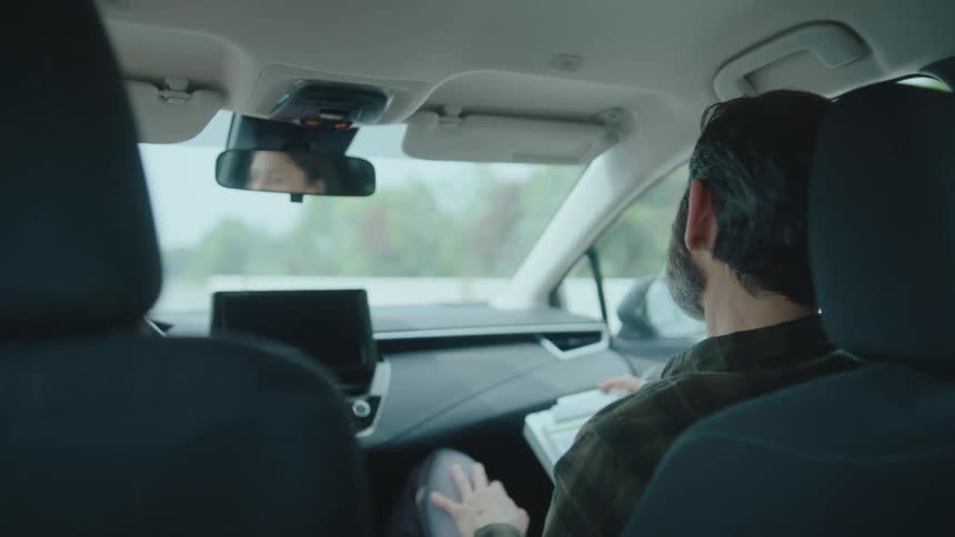 The driving instructor has a clipboard in the passenger seat of the car