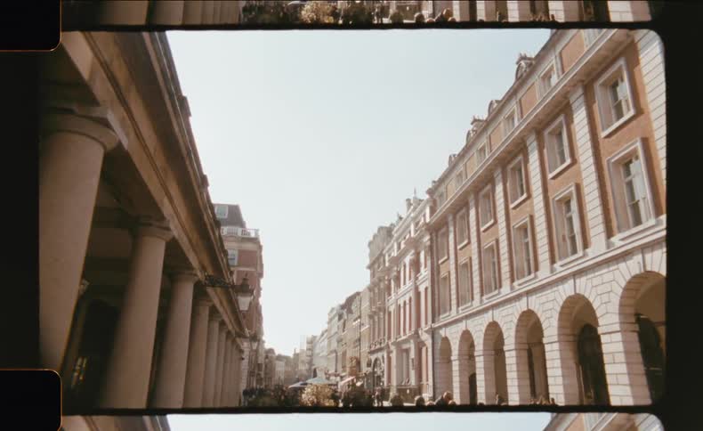 Pedestrians walking on an urban street with classical buildings