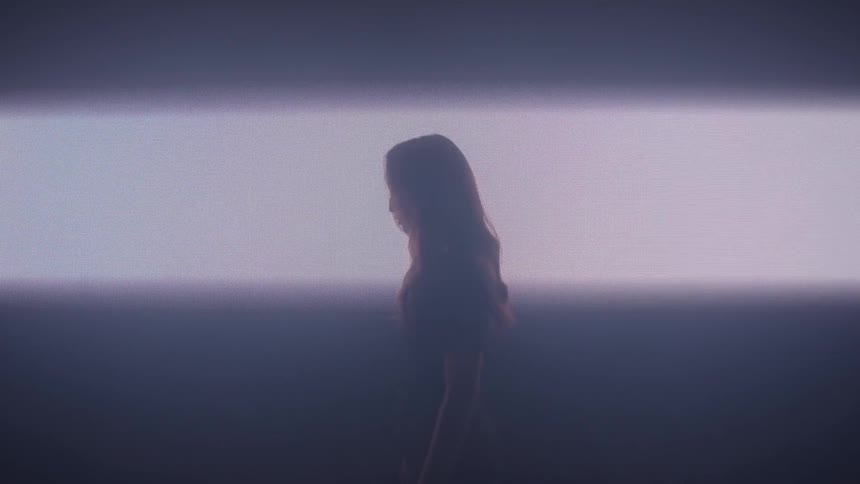 The light opens up on the wall behind the woman turned to the side