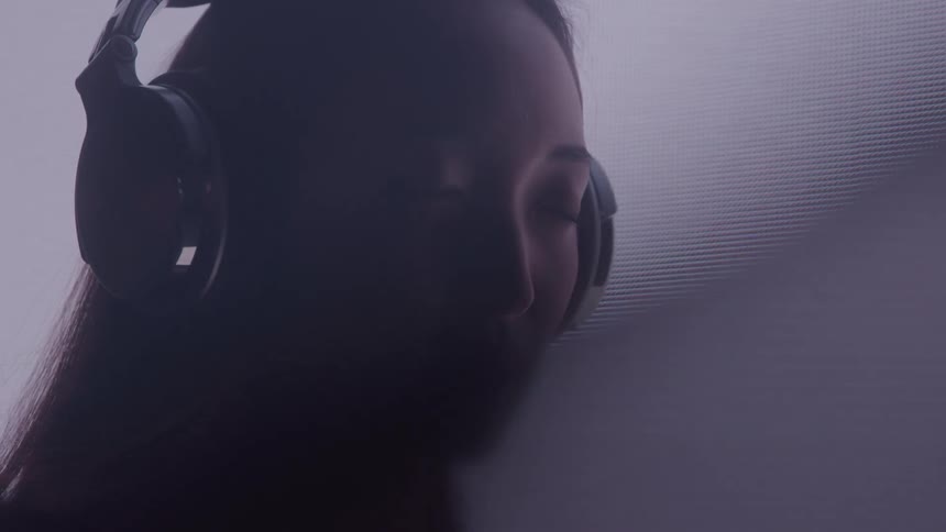 Close up portrait of a young woman listening to audio with headphones