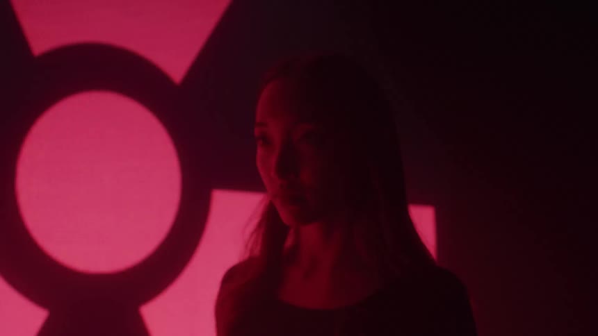 Symbols are flashing on the wall as a woman stars off