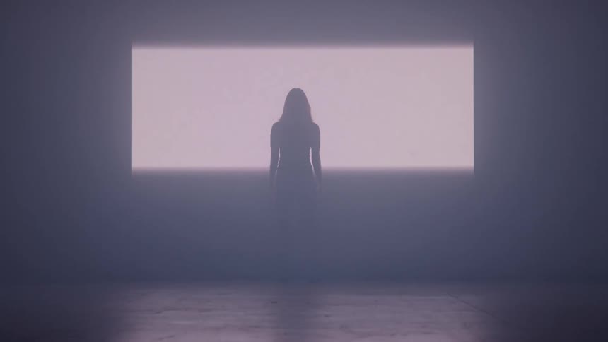 The light fills the wall in front of a woman