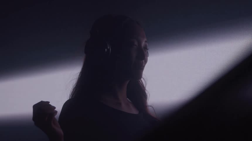 A woman has her eyes closed while listening to headphones