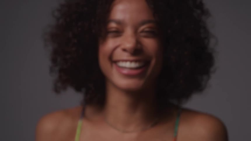 The model laughs and smiles while posing