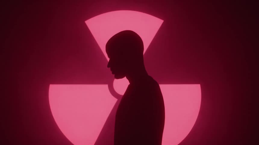 Side silhouette of a man next to a screen displaying red signals